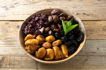 Dried fruits on wooden plate, healthy snack, sweet fruits, rustic style