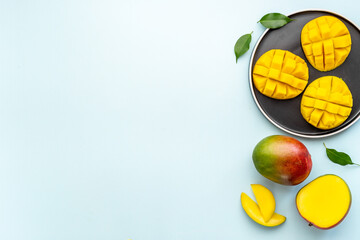 Plate of mango fruits and mango cubes. Tropical breakfast. Top view