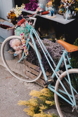 Bicycle with a heart-shaped wreath hanging down next to a table with decorative elements.