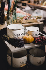 Table in a decoration shop with pumpkins, vases and dried flowers.