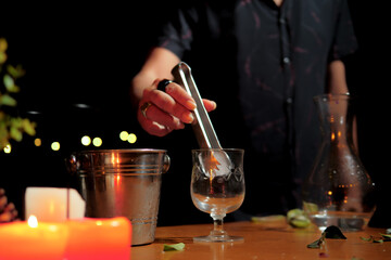 Professional bartender preparing drink with ice and fruits