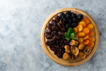Dried fruits on wooden board, healthy snack, sweet fruits, copy space