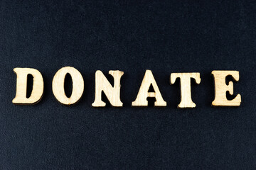 The word donate made from wooden cubes. Conceptual photo. Top view