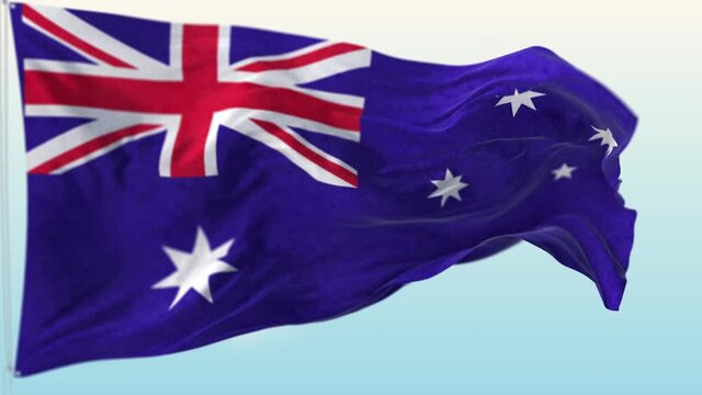 The national flag of Australia blowing in the wind against a blue sky