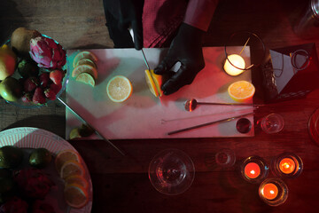 Professional bartender preparing drink with ice and fruits