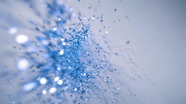 Blue sparkle glitter falls onto white paper background in slow motion, 2 clips