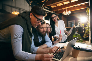 Colleagues working together in modern office using devices and gadgets during creative meeting