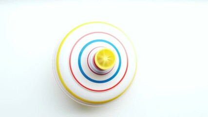 Untwisted whirligig, children toy spinning top spinning on white background.View from top.