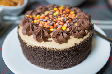 Brown chocolate cake with icing and colourful candies on top, candy cake.