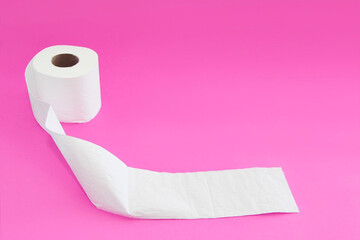 white toilet paper in a roll on a pink background