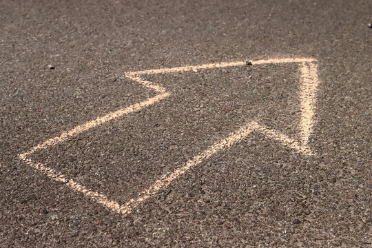 arrow drawn in chalk on the asphalt