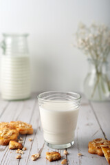 Milk with freshly baked homemade cookies with peanuts on a light background