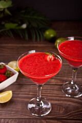Cold strawberry margarita or daiquiri cocktail with lime and rum