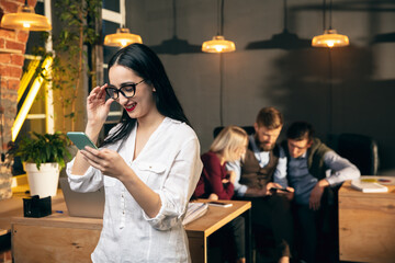 Woman working in modern office using devices and gadgets during creative meeting
