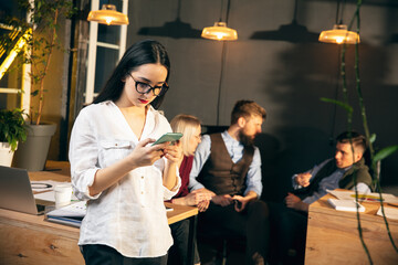 Woman working in modern office using devices and gadgets during creative meeting