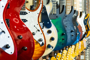 Plakat Row of electric guitars different color in a music instruments shop