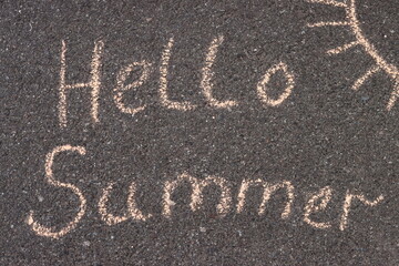 hello summer written in chalk on the asphalt