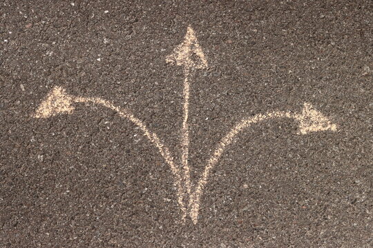 choosing a way with arrows chalk on asphalt