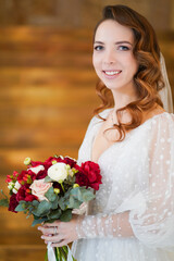 portrait of a bride with long curls, in an elegant dress with a bouquet
