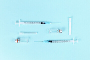 Vaccine vials with syringes on blue background