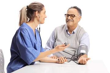 Young female urse checking blood pressure to an elderly man