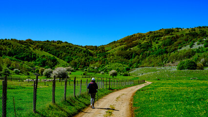 woman walks on footpath in green valley. Valley of the orchids, Campania, Italy