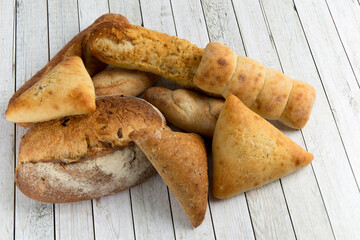 A pile of artisanal bread and buns isolated on white
