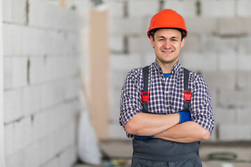 Young handsome worker standing in front of concrete wall