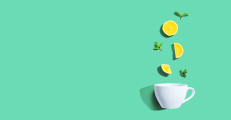 Fresh yellow lemons with tea cup overhead view