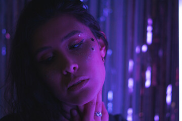 woman with glitter makeup and stars with purple neon light