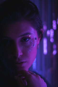 woman with glitter makeup and stars with purple neon light