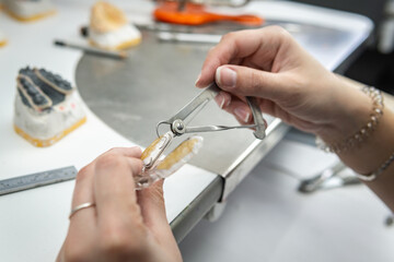 Dental technician manufacturing orthodontic dental prosthesis. Workplace of a dental technician