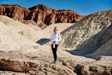 Fototapeta premium A family hike from Zabriskie Point in Death Valley national park in california. Huge sand dunes, terracotta mountains and hazy horizons are shining against clear blue sky in the midday sun.