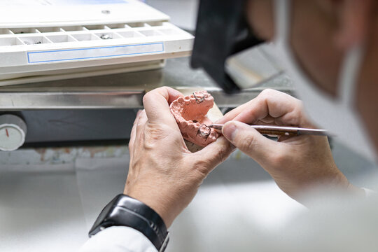 Dental technician manufacturing orthodontic dental prosthesis. Workplace of a dental technician