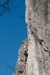 Latin male climber pulls the rope while ascending a route.