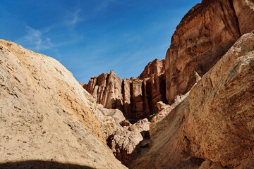 Fototapeta premium A family hike from Zabriskie Point in Death Valley national park in california. Huge sand dunes, terracotta mountains and hazy horizons are shining against clear blue sky in the midday sun.