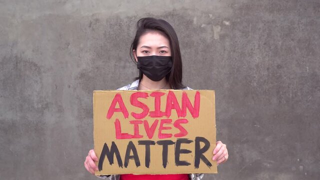 Asian woman with poster during protest against sexual harassment