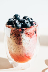 Healthy chia pudding in a glass with fresh blueberries