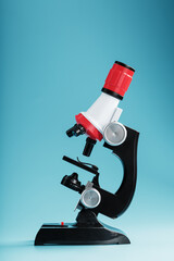 Microscope for laboratory medical research and experiments on a blue background.