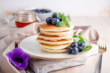 Homemade pancakes with blueberries and powdered sugar on the white table