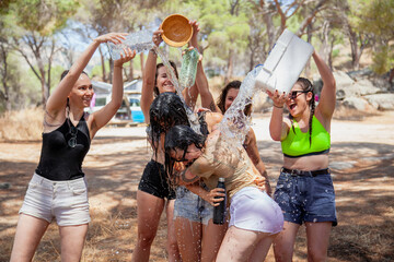 San martin de Valdeiglesias, Madrid, Spain. Group of women playing with water to cool off in summer near a fountain.