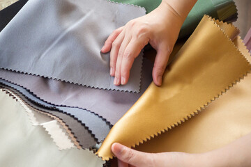 female designer with fabric color samples choosing textile for curtains