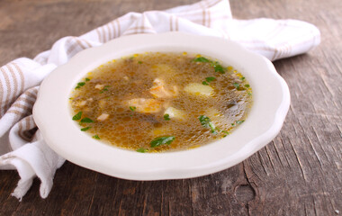 Mushroom soup with chicken and barley. Decorated with greenery. On an old wooden background. 