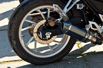 Fototapeta premium Motorcycle wheel closeup. Motorcycle metal parts. Biker meeting in the city.