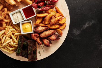 tackler with snacks on black textured background top view