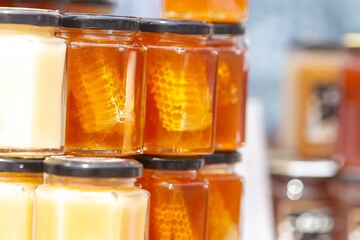 Fresh honey in glass jars with pieces of honeycomb, food concept.