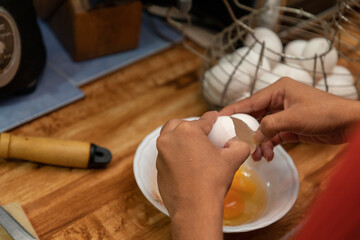 Close up of latin woman breaking egg and making sunny side up eggs.
