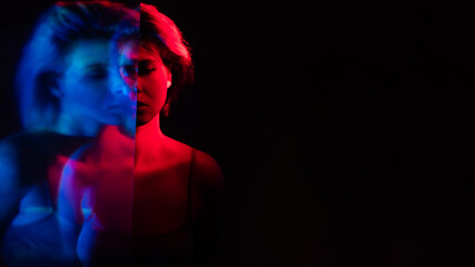 Bipolar disorder. Emotional crisis. Depression loneliness. Blur double exposure silhouette of disturbed upset woman in pink blue neon light isolated on black copy space background.