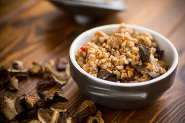 boiled buckwheat with organic forest dried mushrooms in a ceramic bowl