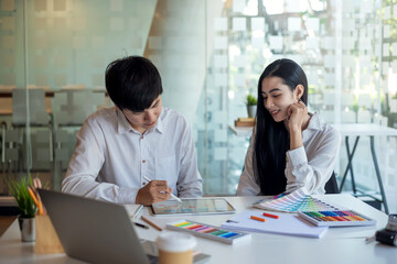 Team Asian designer people made graphics using a tablet with a color sample at the office.